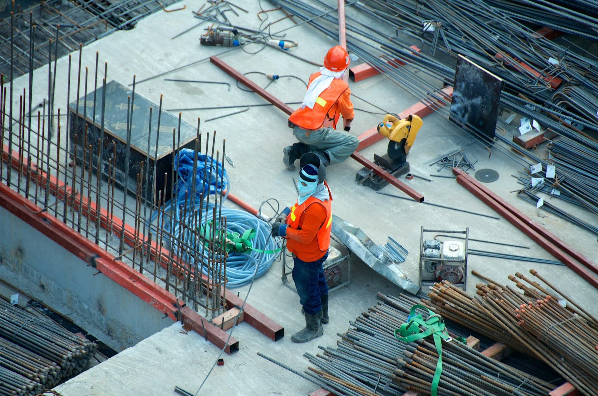 Ingenieros civiles con cascos revisando planos en una obra de construcción